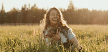 Lady kissing her brown dachshund puppy