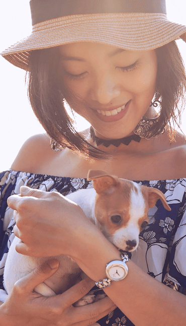 Young woman hugging a small puppy