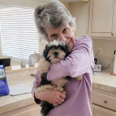 Older lady hugging her recently purchased puppy