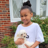 Young girl holding her puppy and smiling