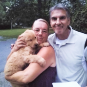 Husband and wife holding their newly received puppy